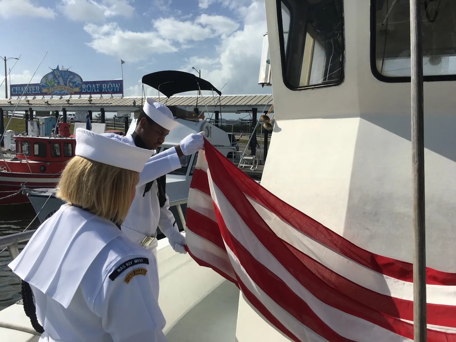 Honor guard folding the American flag during a veterans' memorial service at sea